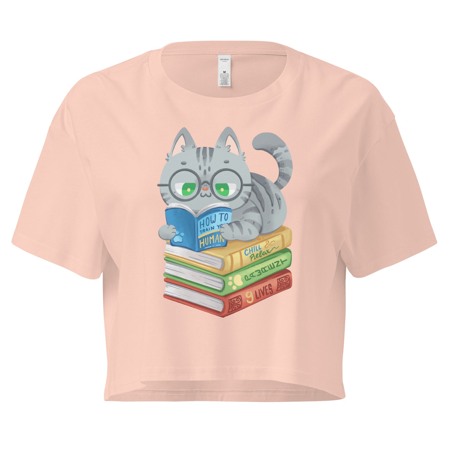 Peach crop top with cat in glasses reading on top of a pile of books design